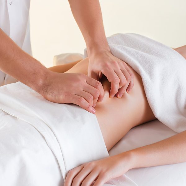 The picture of beautiful woman in massage salon and male hands on her body